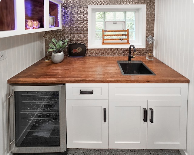 bar with a sink, wine cooler, and tasteful backsplash