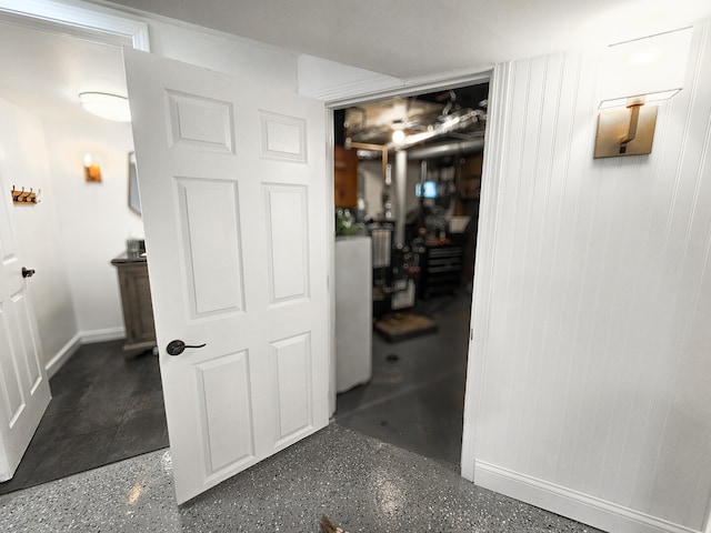 hallway featuring speckled floor and baseboards