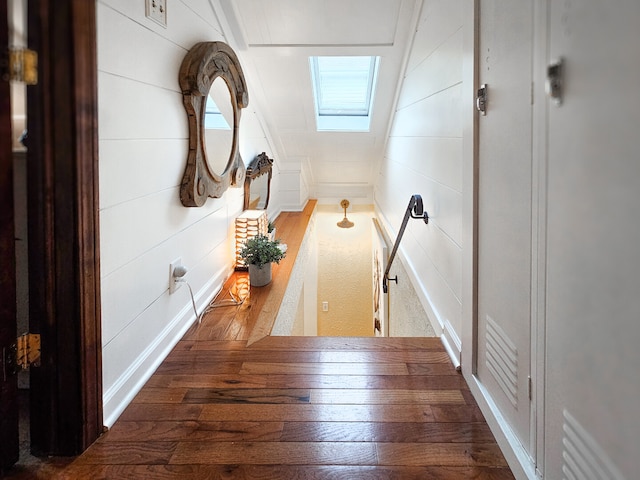 hallway with a skylight and wood finished floors