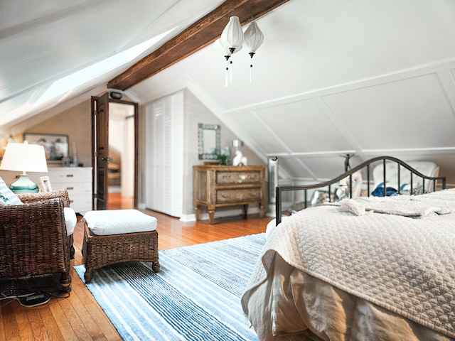 bedroom featuring lofted ceiling with beams and wood-type flooring