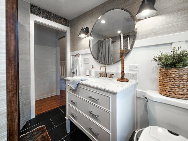 full bathroom with toilet, vanity, and tile patterned flooring