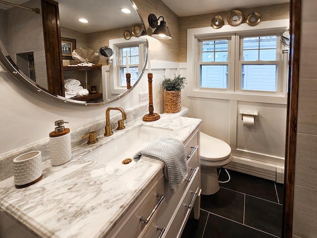 bathroom with vanity, a wainscoted wall, a baseboard radiator, tile patterned floors, and toilet