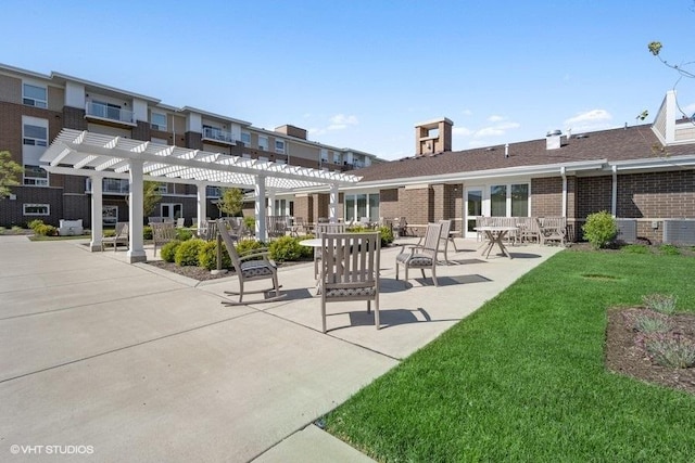 exterior space with a patio, a yard, brick siding, and a pergola