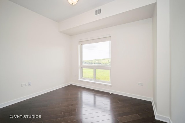 unfurnished room with visible vents, baseboards, and dark wood-style floors