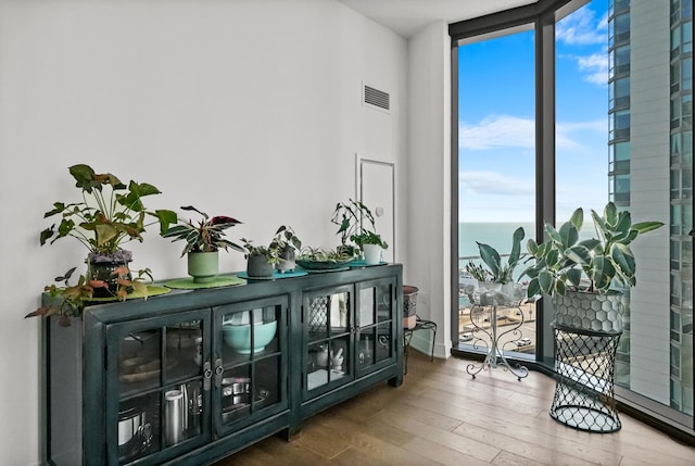 sitting room featuring visible vents, wood finished floors, and expansive windows