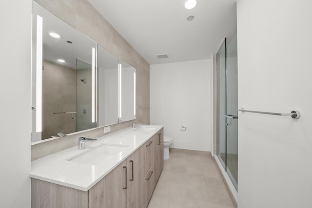 bathroom featuring a shower stall, toilet, visible vents, and a sink