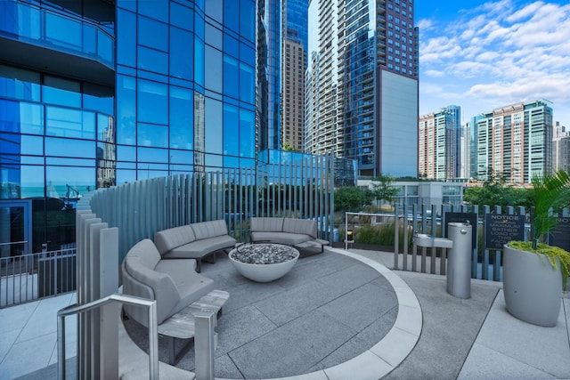 view of patio / terrace with a view of city and an outdoor living space with a fire pit