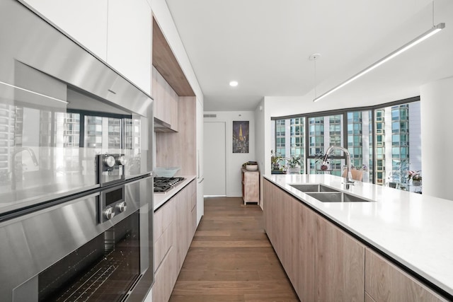 kitchen with a sink, modern cabinets, appliances with stainless steel finishes, and light countertops