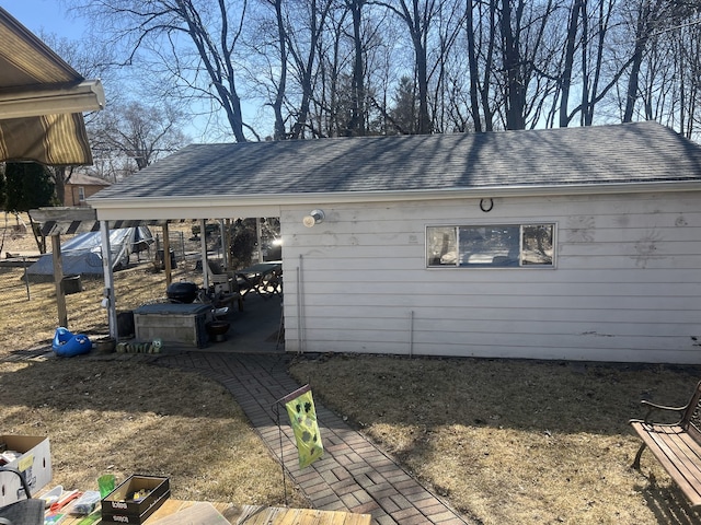 rear view of house featuring roof with shingles