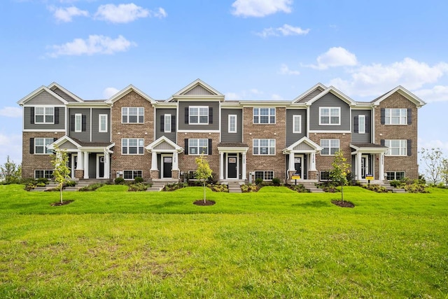 view of front of home featuring a front lawn and brick siding