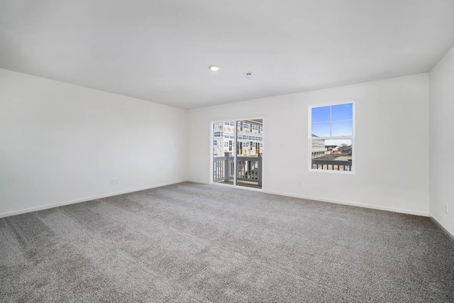 carpeted empty room featuring baseboards