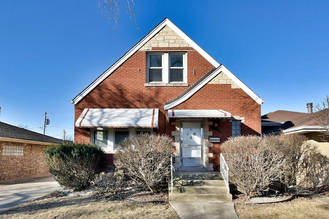 view of front facade featuring brick siding and stone siding