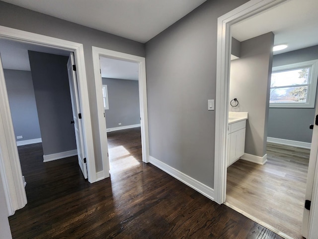 hallway featuring dark wood-style floors and baseboards