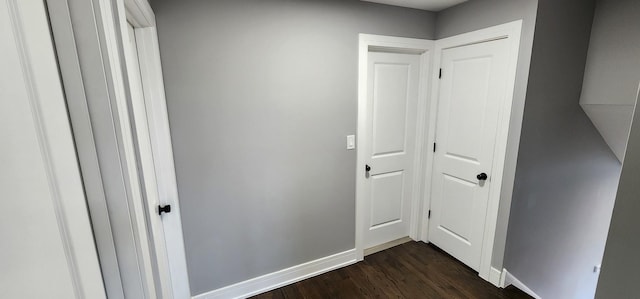 corridor with dark wood finished floors and baseboards