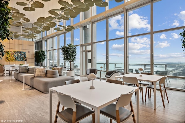 dining area featuring a wall of windows and a towering ceiling