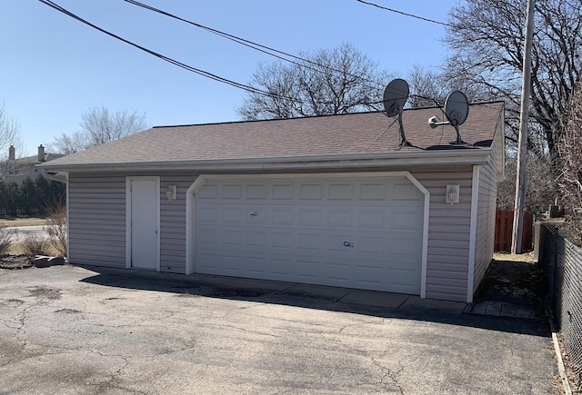 detached garage featuring fence