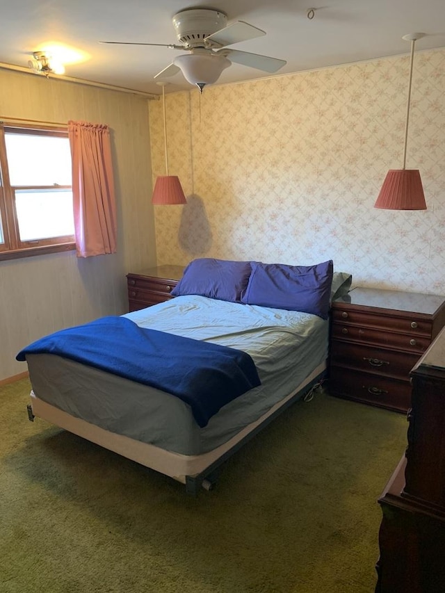 carpeted bedroom featuring wallpapered walls and a ceiling fan