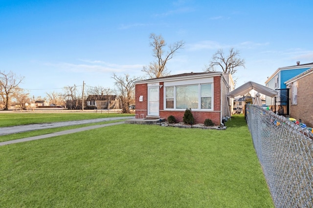 view of front of property featuring brick siding, a front yard, and fence