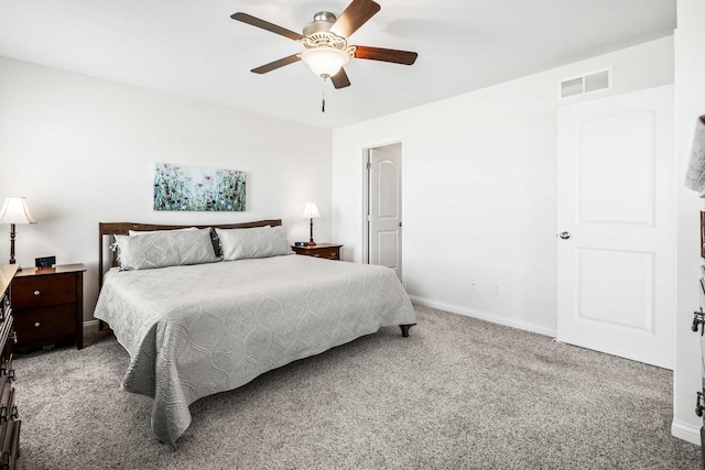 carpeted bedroom with visible vents, baseboards, and a ceiling fan