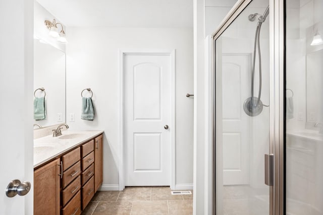 bathroom featuring double vanity, baseboards, a stall shower, and a sink