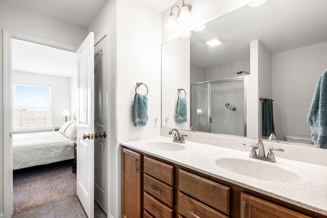 bathroom featuring tile patterned floors, a shower stall, double vanity, and a sink