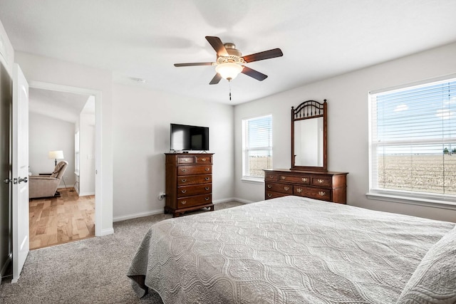 carpeted bedroom with ceiling fan and baseboards