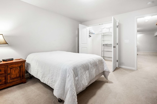 bedroom featuring light colored carpet and baseboards