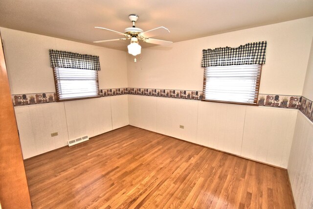 unfurnished room with light wood-type flooring, visible vents, baseboards, and a ceiling fan