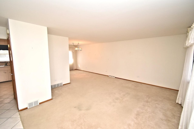 unfurnished living room with visible vents, carpet floors, an inviting chandelier, and stairway