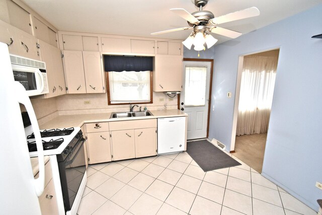 kitchen with a ceiling fan, a sink, white appliances, light countertops, and light tile patterned floors