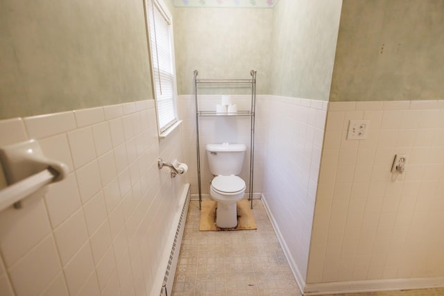 bathroom featuring tile walls, toilet, wainscoting, and a baseboard radiator