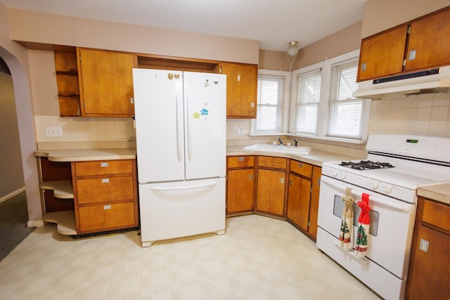 kitchen featuring white appliances, light floors, open shelves, a sink, and under cabinet range hood