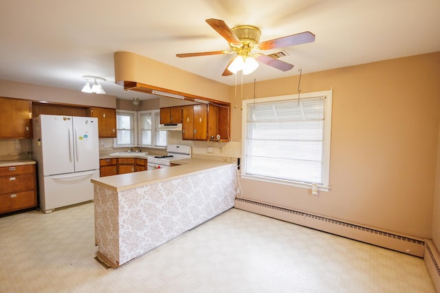 kitchen with brown cabinets, a sink, white appliances, a baseboard radiator, and light floors