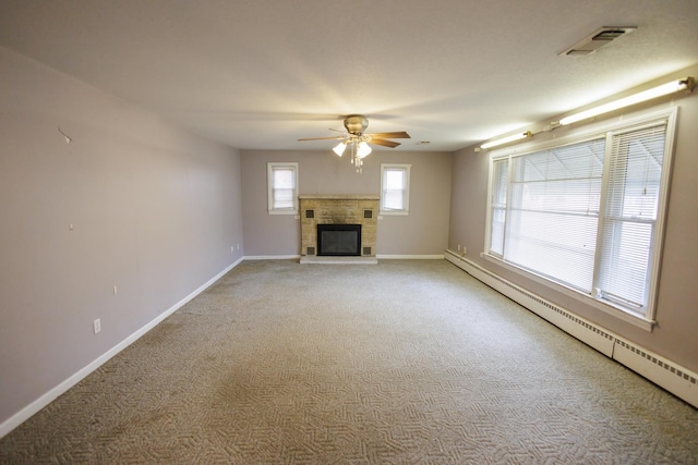 unfurnished living room featuring baseboards, visible vents, a baseboard radiator, a glass covered fireplace, and light colored carpet