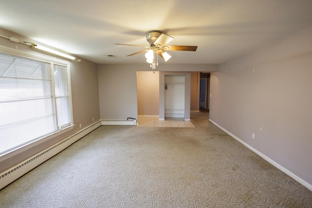 empty room with visible vents, ceiling fan, baseboards, light carpet, and a baseboard radiator