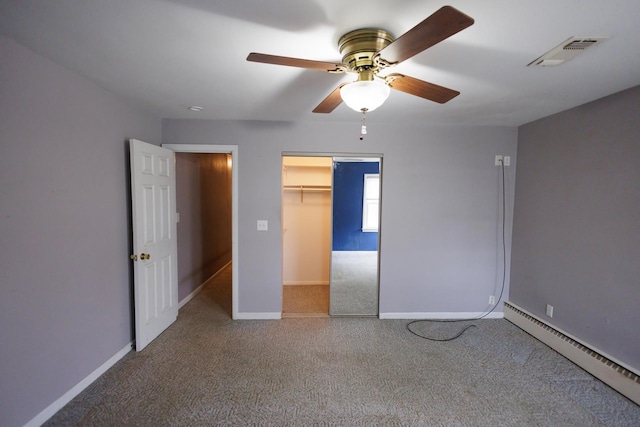 unfurnished bedroom with visible vents, baseboards, a baseboard heating unit, and carpet flooring