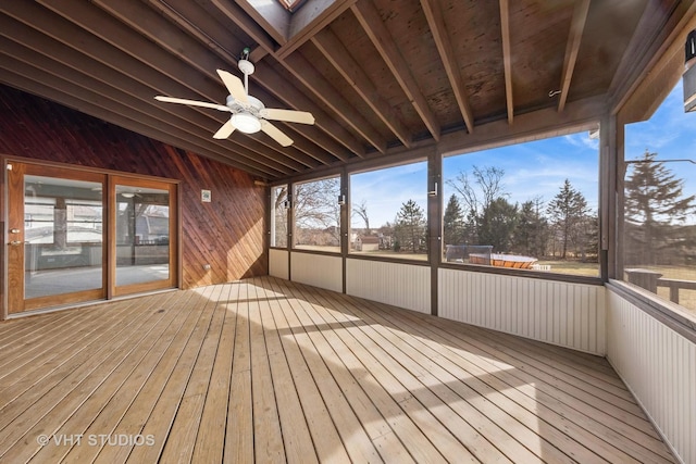 unfurnished sunroom featuring vaulted ceiling with skylight and a ceiling fan