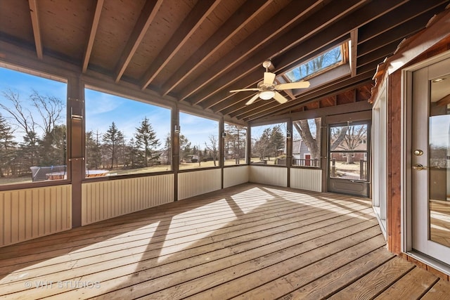 unfurnished sunroom featuring vaulted ceiling with skylight and ceiling fan