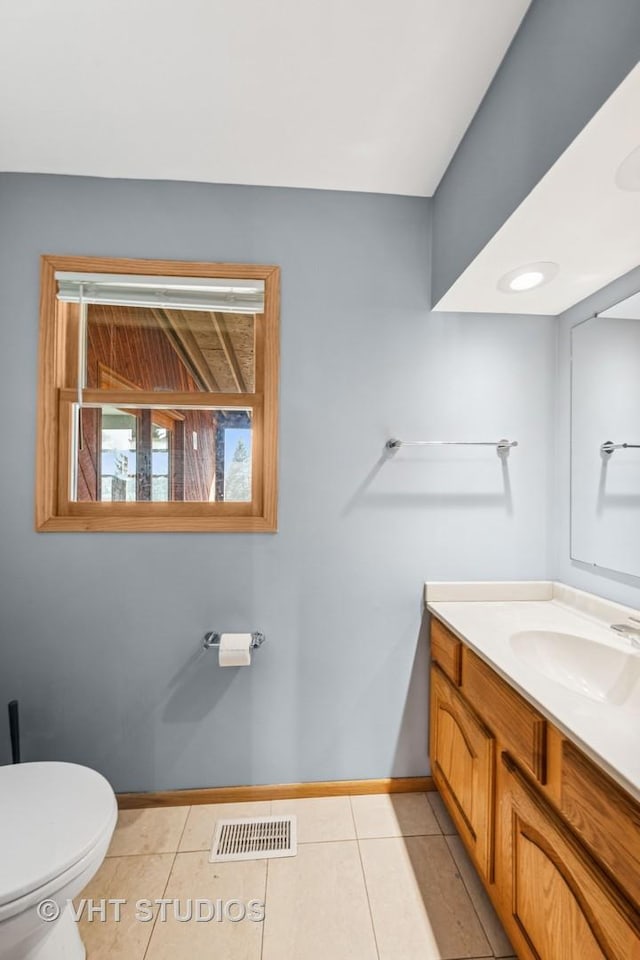 bathroom with tile patterned flooring, visible vents, baseboards, toilet, and vanity