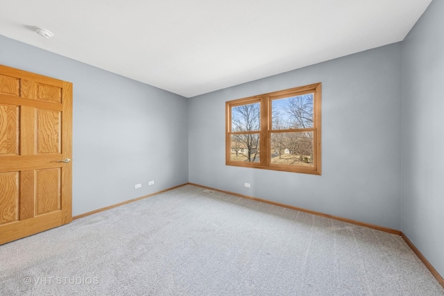 carpeted spare room featuring visible vents and baseboards