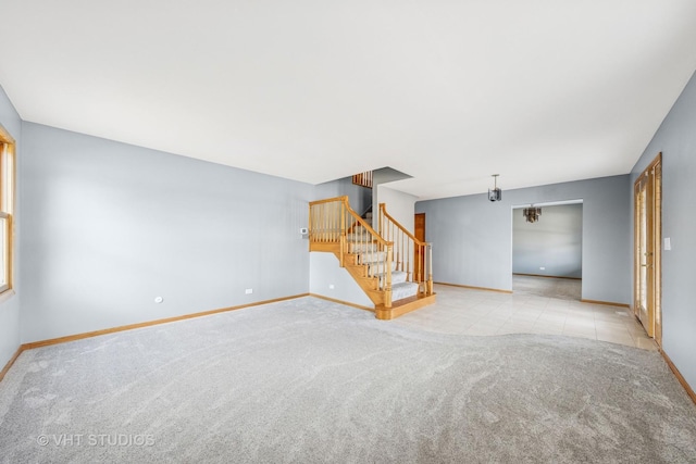 unfurnished living room with tile patterned flooring, carpet flooring, stairs, and baseboards