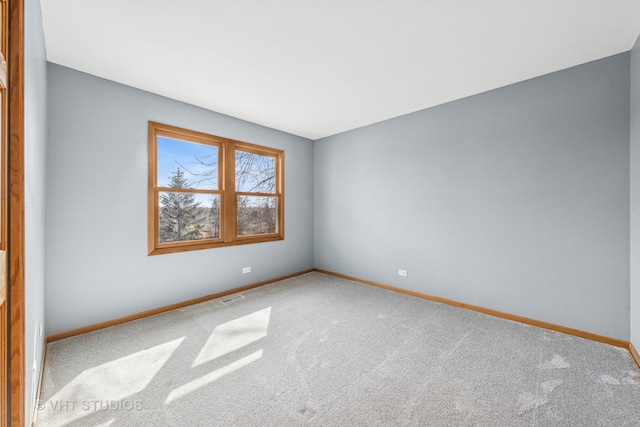 carpeted empty room featuring visible vents and baseboards