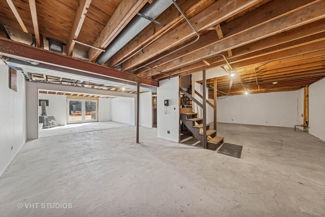 unfinished below grade area with stairway and a wood stove