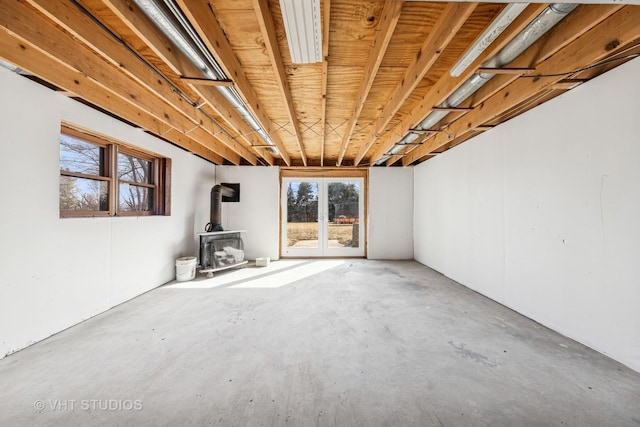 interior space with unfinished concrete floors and a wood stove