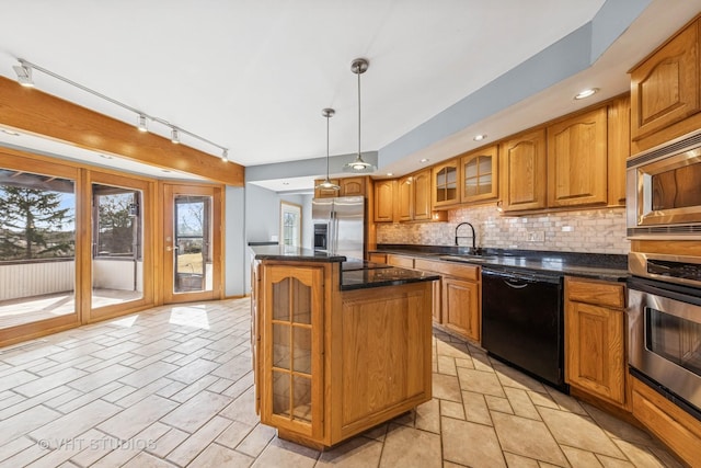 kitchen featuring a kitchen island, a sink, decorative backsplash, appliances with stainless steel finishes, and brown cabinets