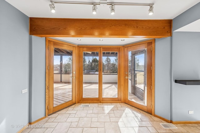 doorway featuring plenty of natural light, baseboards, and visible vents