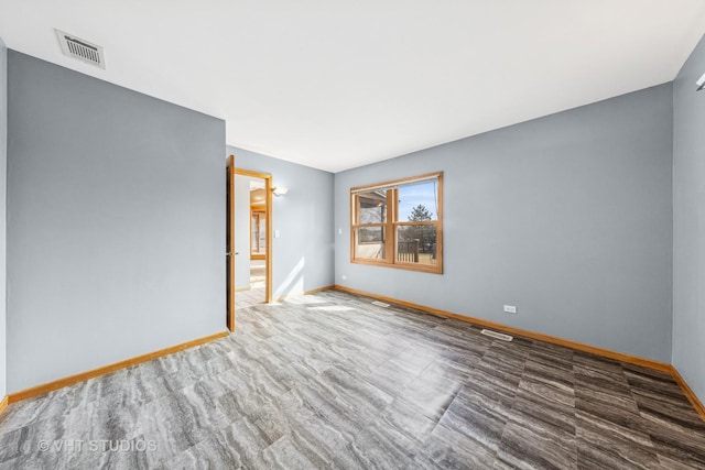 unfurnished room featuring visible vents and baseboards