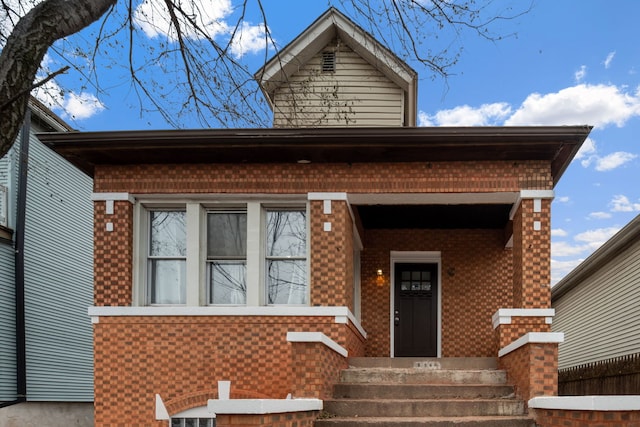 view of front facade featuring brick siding and fence