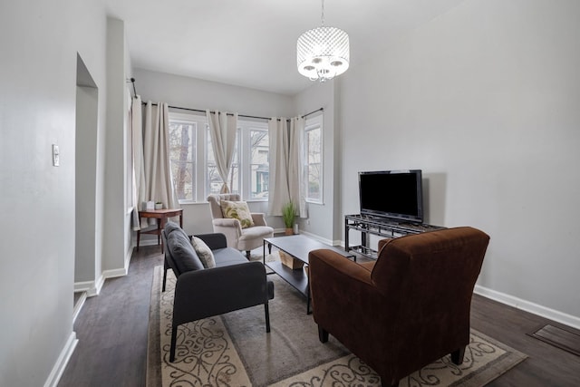 living room with a notable chandelier, wood finished floors, and baseboards