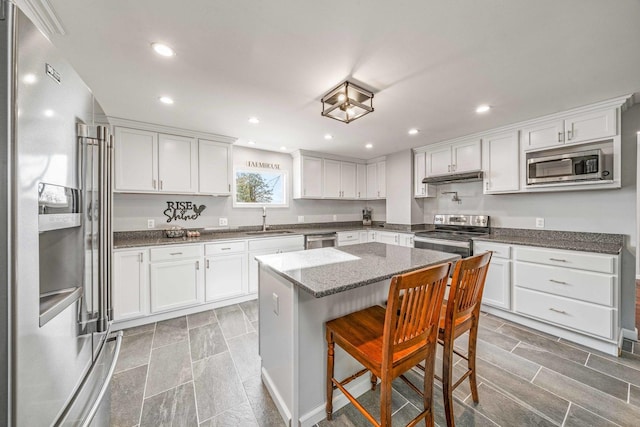 kitchen with a sink, white cabinetry, under cabinet range hood, and stainless steel appliances